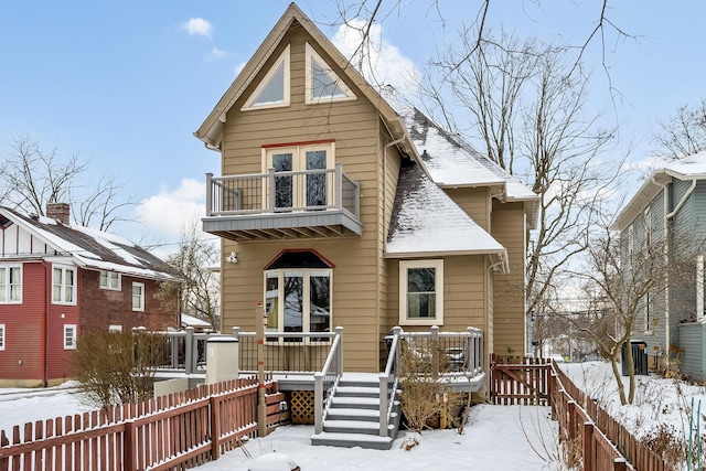 snow covered house featuring a balcony