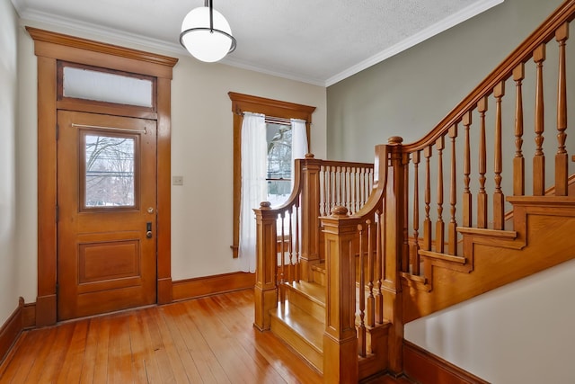 entrance foyer featuring crown molding, a textured ceiling, and light wood-type flooring