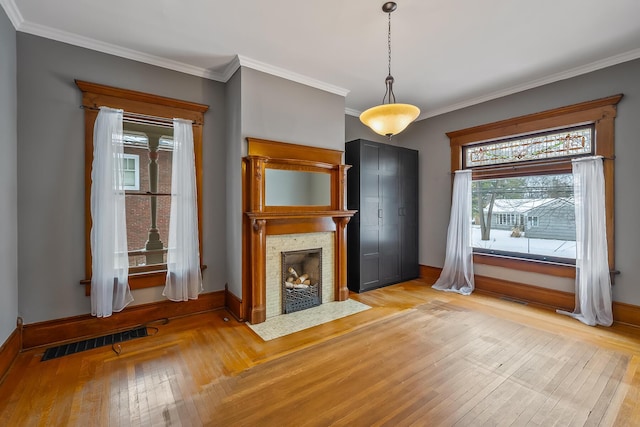 unfurnished living room with light hardwood / wood-style floors and crown molding