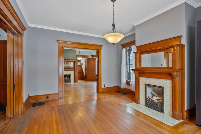 unfurnished living room with wood-type flooring and ornamental molding