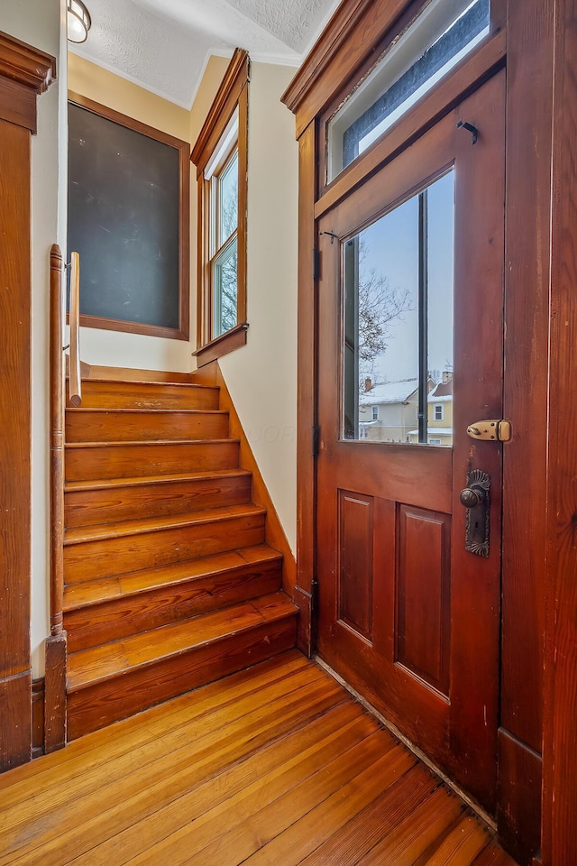 foyer entrance with plenty of natural light, wood-type flooring, and a textured ceiling