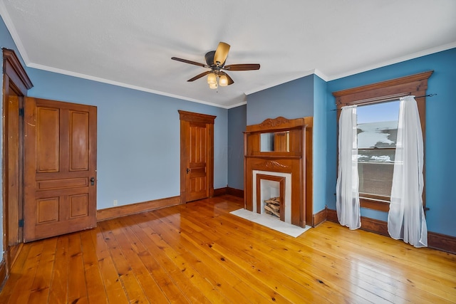 unfurnished living room featuring ceiling fan, light wood-type flooring, and ornamental molding