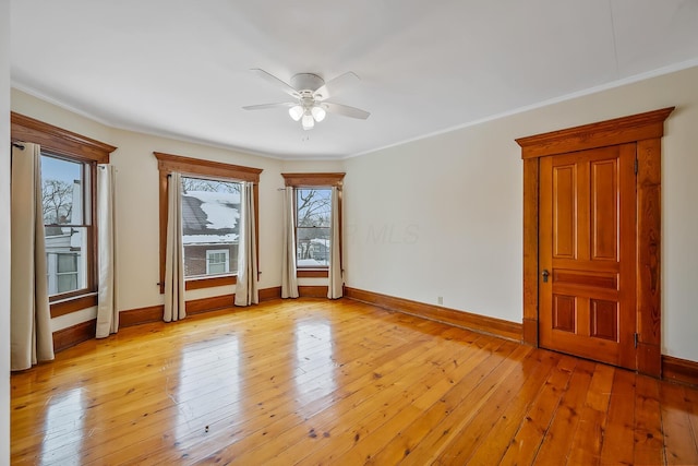 spare room with ceiling fan, crown molding, and light hardwood / wood-style floors