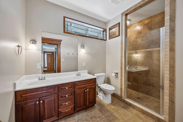 bathroom featuring tile patterned flooring, vanity, toilet, and walk in shower