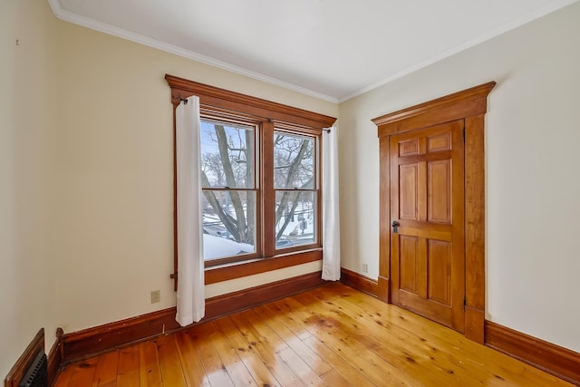 empty room featuring light hardwood / wood-style floors and ornamental molding