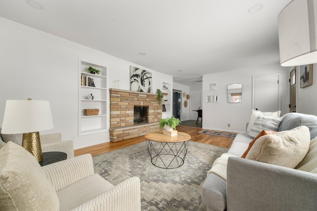 living room with built in shelves and wood-type flooring