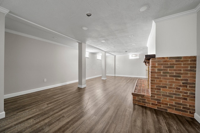 basement featuring a textured ceiling, ornamental molding, and dark hardwood / wood-style floors