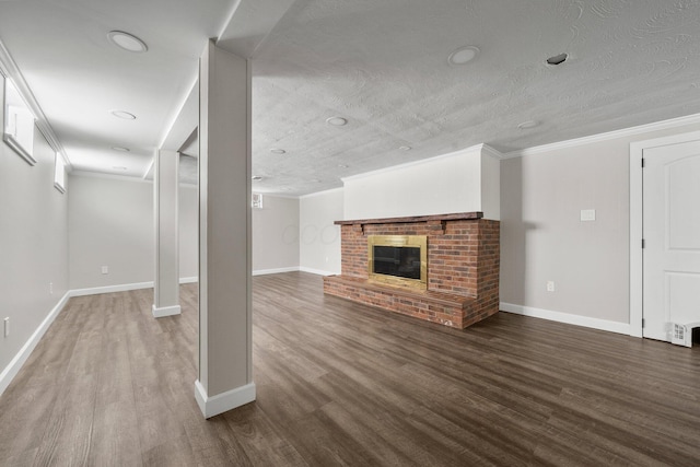 unfurnished living room with a brick fireplace, a textured ceiling, crown molding, and hardwood / wood-style flooring