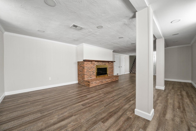 unfurnished living room featuring a textured ceiling, dark wood-type flooring, crown molding, and a fireplace