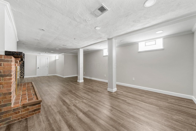 basement featuring a textured ceiling and hardwood / wood-style floors