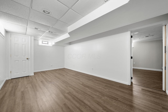 basement with a paneled ceiling and hardwood / wood-style floors