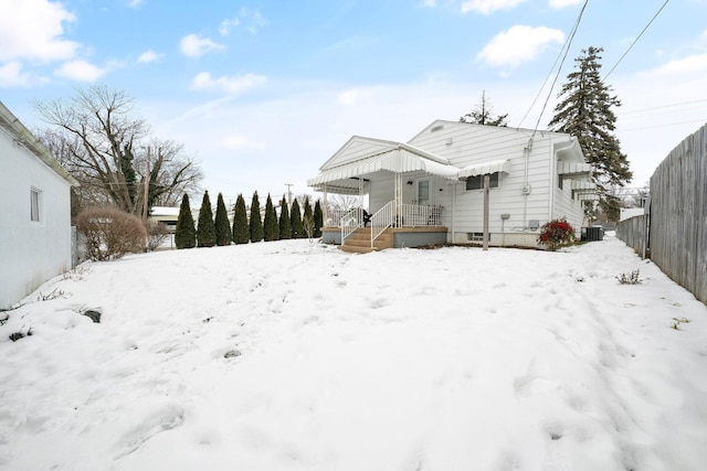 snow covered back of property featuring a porch and central air condition unit