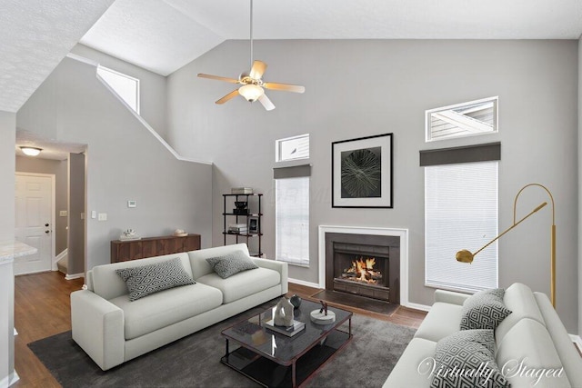 living room featuring high vaulted ceiling, ceiling fan, and dark wood-type flooring