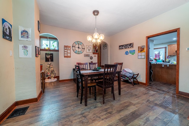 dining space featuring dark hardwood / wood-style floors and a notable chandelier