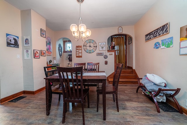 dining room with dark hardwood / wood-style flooring and a notable chandelier