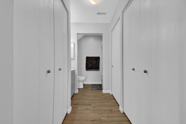 hallway featuring light wood-type flooring and a textured ceiling