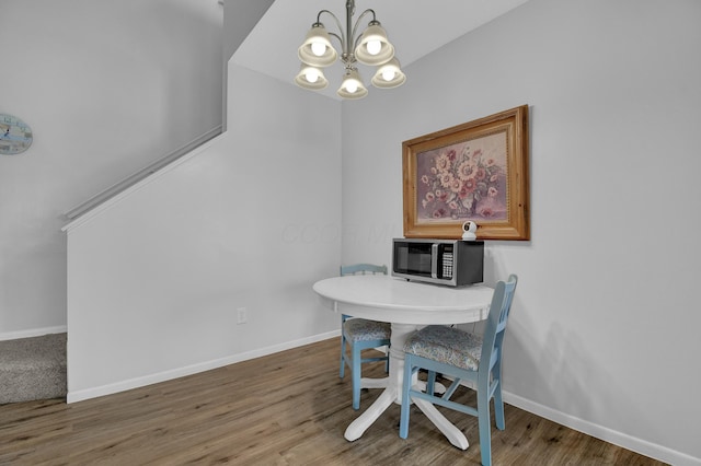 dining room with hardwood / wood-style floors and a notable chandelier