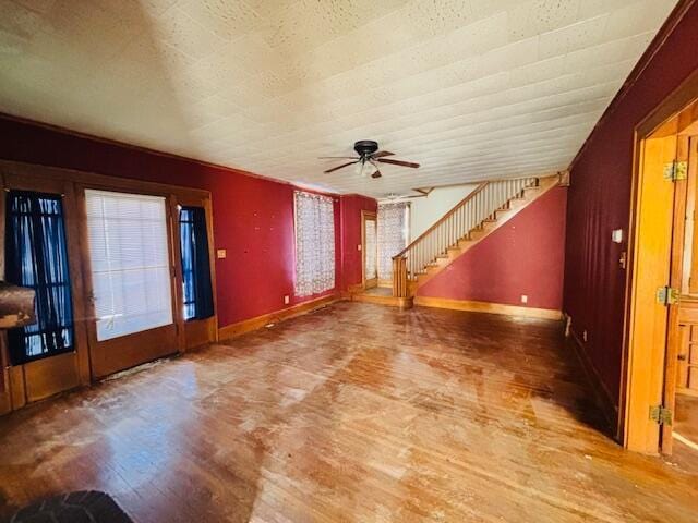 unfurnished living room featuring ceiling fan, wood-type flooring, and a textured ceiling