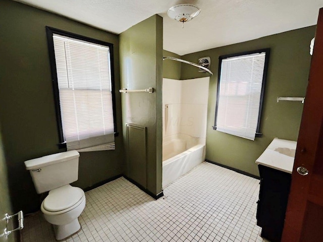 bathroom with baseboards, toilet, vanity, and  shower combination