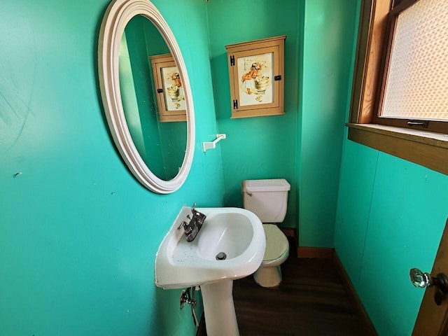 bathroom featuring toilet, baseboards, and wood finished floors