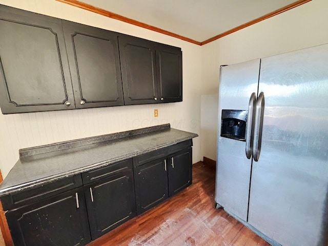 kitchen featuring dark countertops, dark cabinetry, stainless steel refrigerator with ice dispenser, and wood finished floors