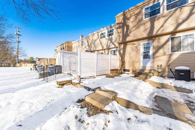 snow covered property with cooling unit