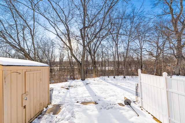 snowy yard featuring a storage unit