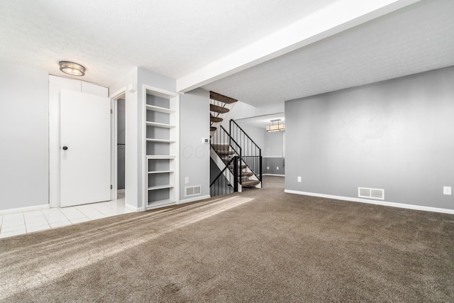 interior space with light colored carpet and a textured ceiling