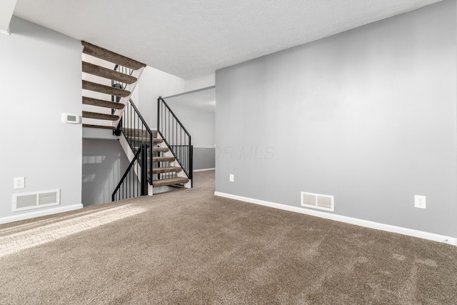 unfurnished living room with carpet and a textured ceiling