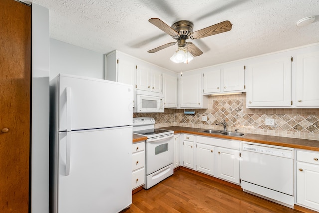 kitchen with tasteful backsplash, white appliances, sink, light hardwood / wood-style flooring, and white cabinetry