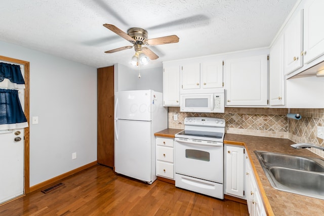 kitchen with white appliances, tasteful backsplash, white cabinetry, and sink