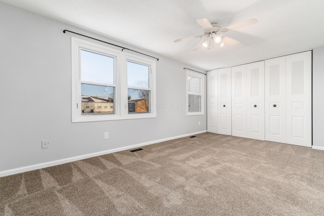 unfurnished bedroom featuring ceiling fan, a closet, and carpet