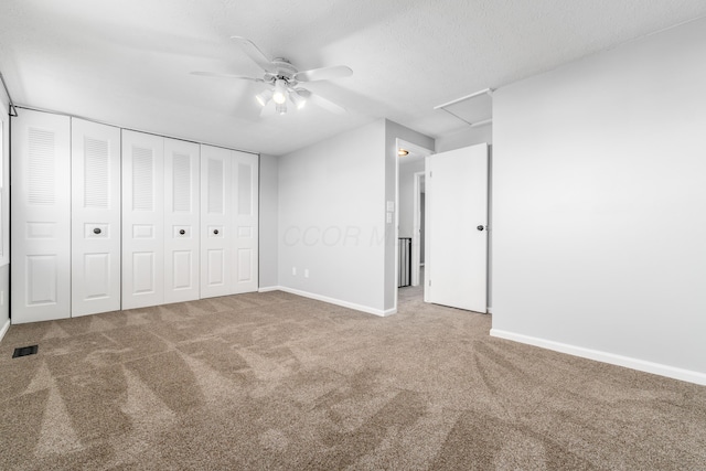 unfurnished bedroom featuring carpet flooring, ceiling fan, a textured ceiling, and a closet