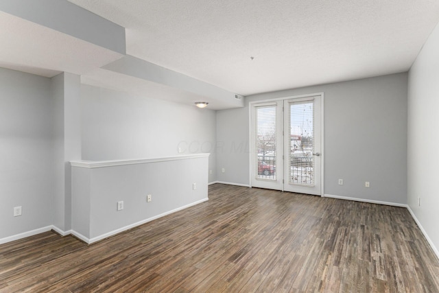 spare room with a textured ceiling and dark wood-type flooring