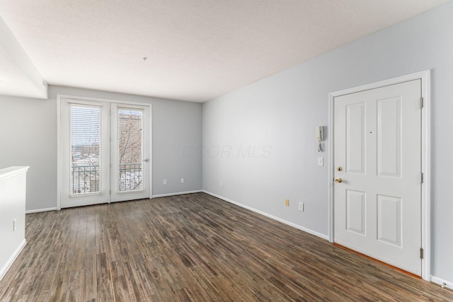 spare room with dark hardwood / wood-style flooring and a textured ceiling