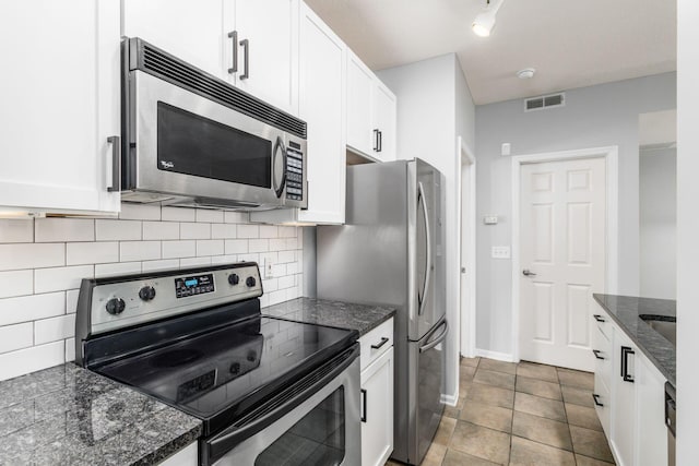 kitchen featuring appliances with stainless steel finishes, backsplash, white cabinetry, and light tile patterned flooring