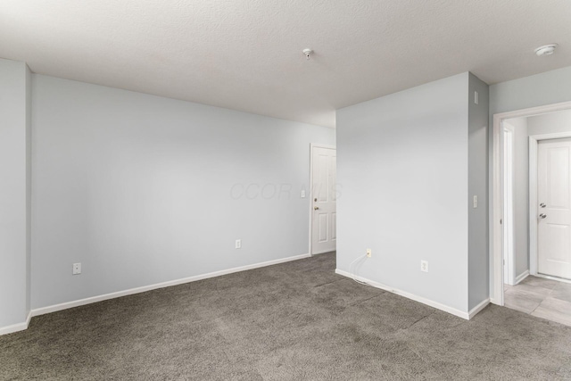 spare room featuring carpet floors and a textured ceiling