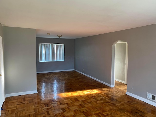 unfurnished room with dark parquet flooring