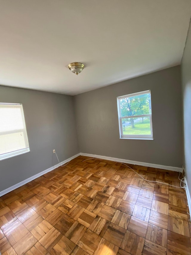 unfurnished room featuring plenty of natural light and light parquet floors