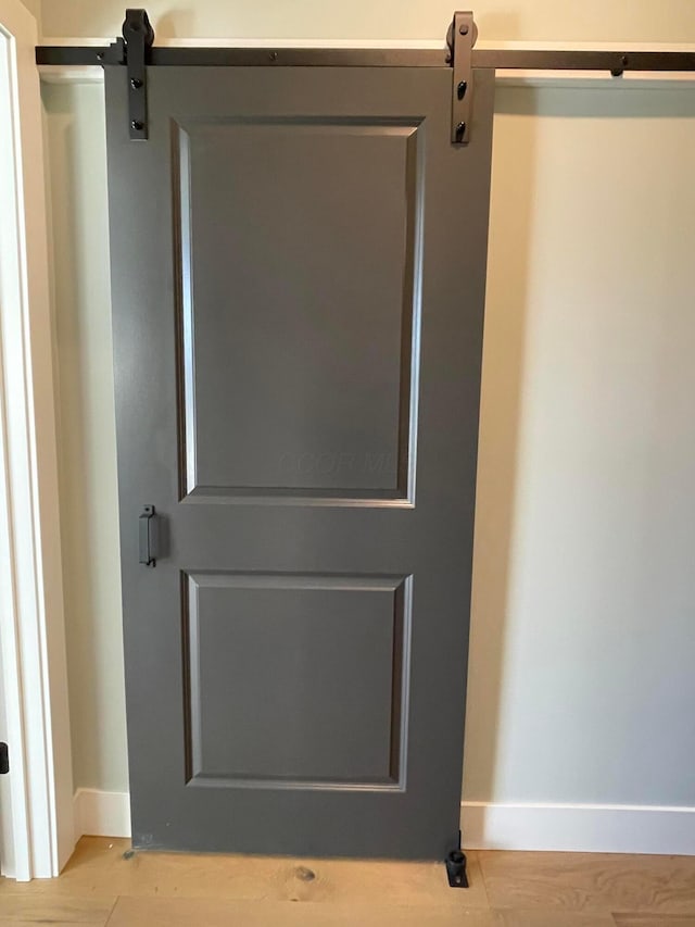 interior details with hardwood / wood-style flooring and a barn door