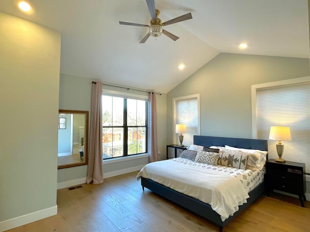 bedroom with ceiling fan, light hardwood / wood-style flooring, and vaulted ceiling