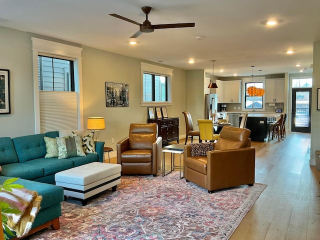 living room with ceiling fan and light hardwood / wood-style flooring