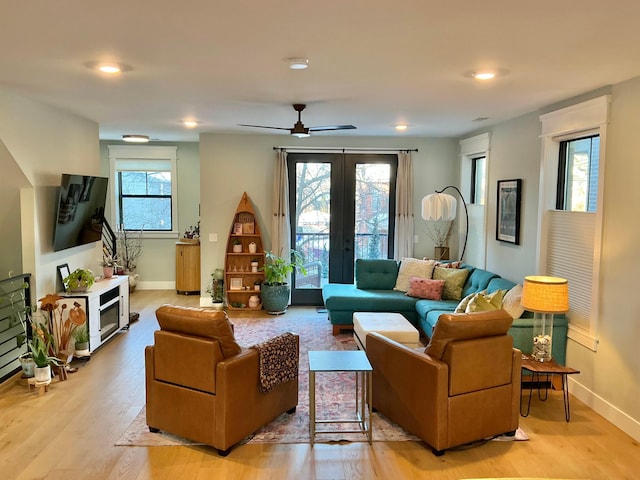 living room with ceiling fan, french doors, plenty of natural light, and light hardwood / wood-style floors