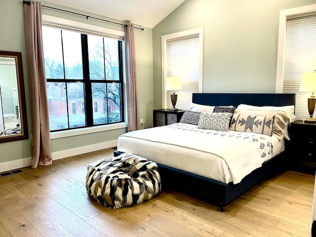 bedroom with vaulted ceiling and light hardwood / wood-style floors