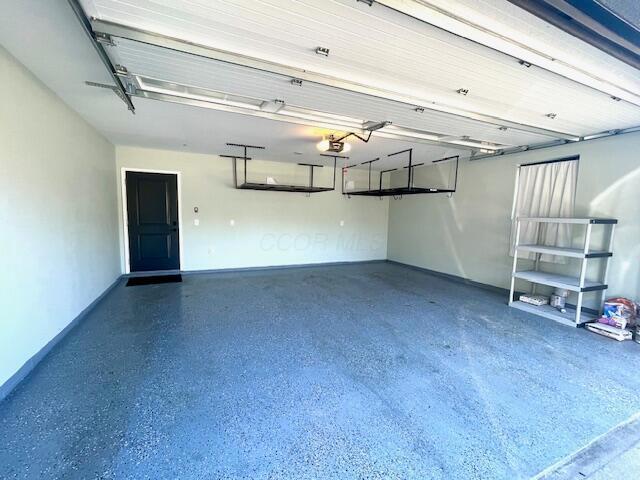 garage featuring a garage door opener and baseboards