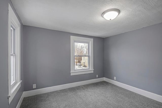 empty room featuring a textured ceiling and carpet floors