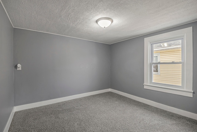 carpeted empty room with a textured ceiling