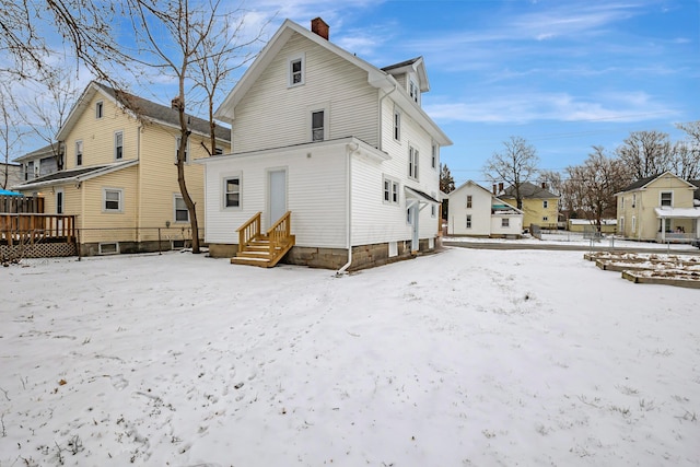 view of snow covered back of property