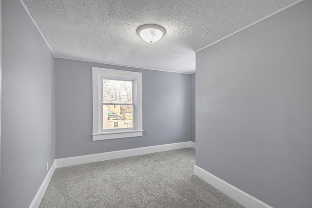 unfurnished room featuring carpet and a textured ceiling