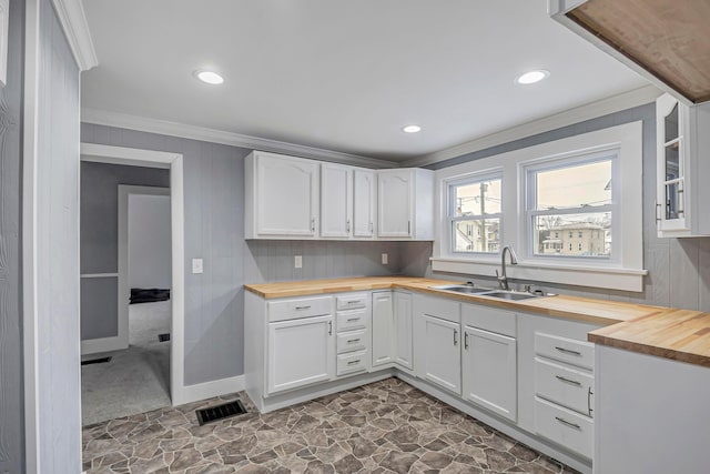 kitchen featuring white cabinets, sink, and wooden counters